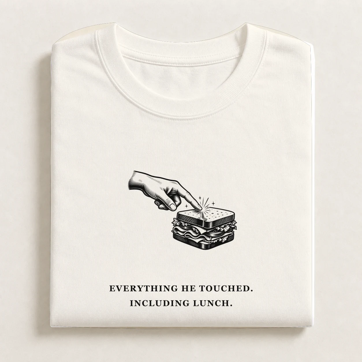 Midas Touch printed on a folded Ecru T-shirt.